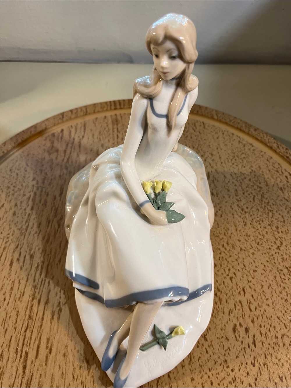 Porcelain Figurine of Seated Girl in White and Blue Holding Yellow Flowers